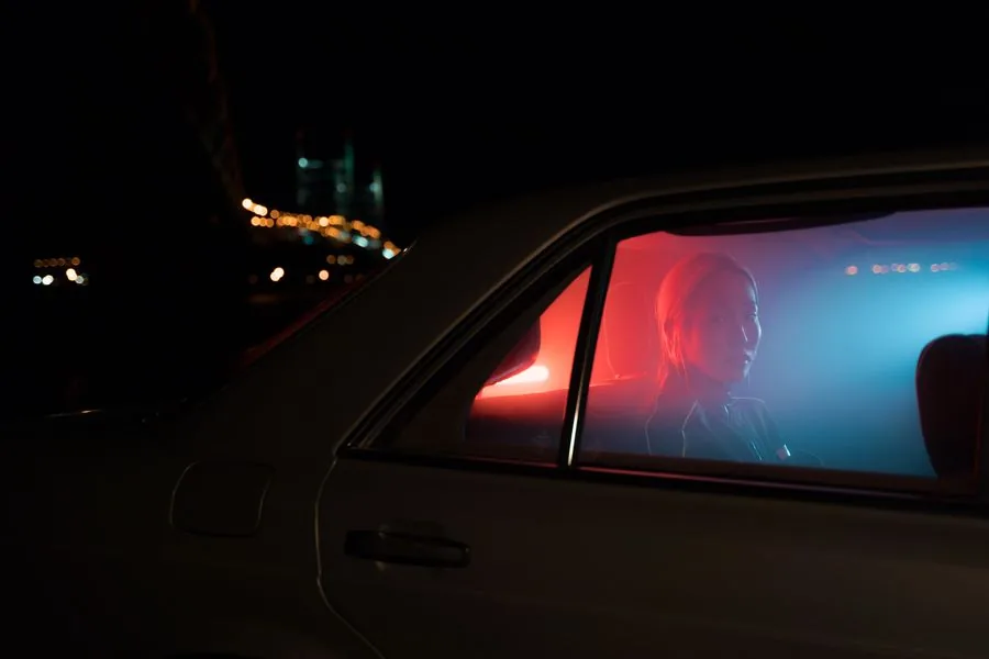 A passenger riding in the back seat of a car