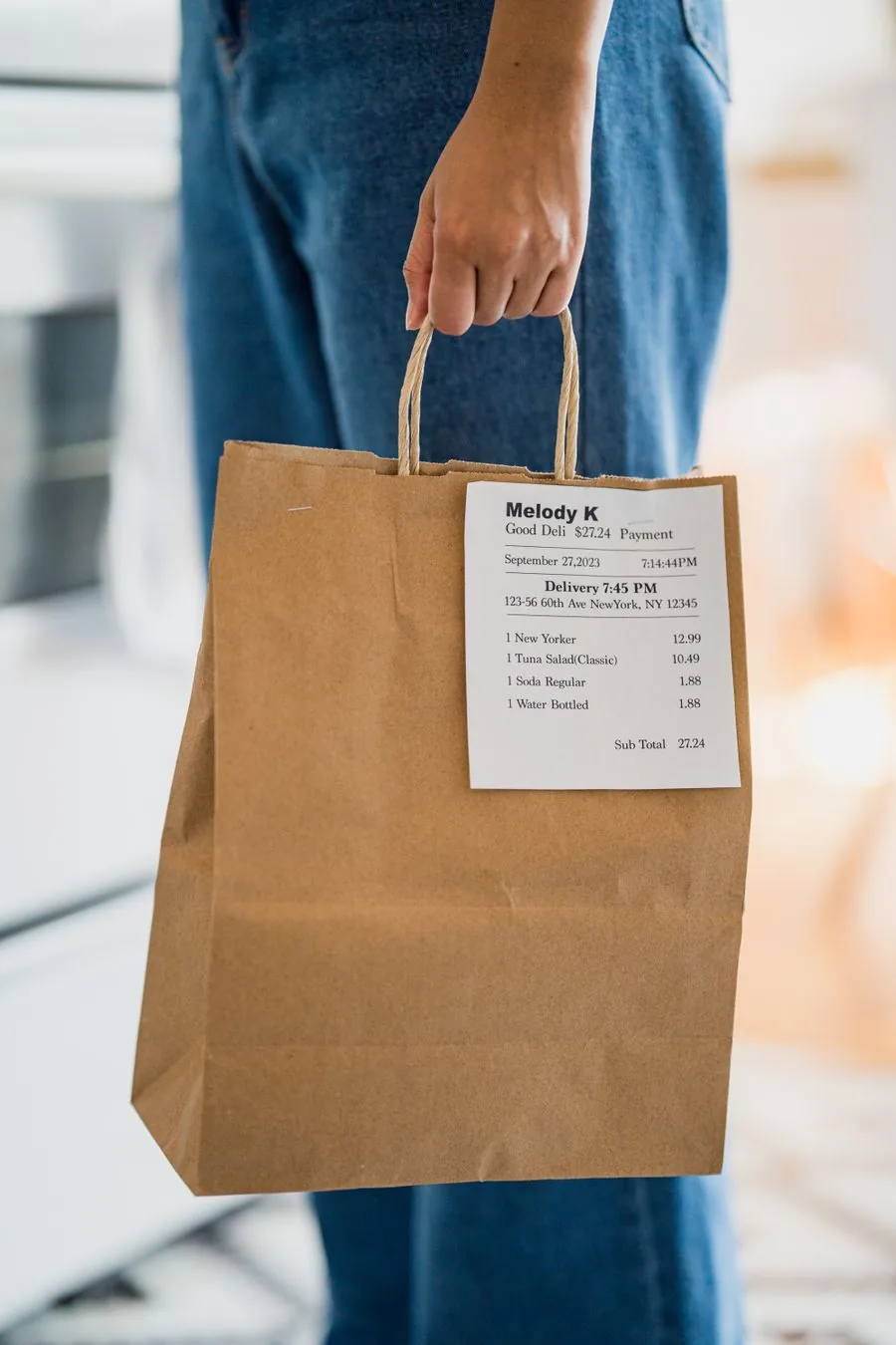 A paper lunch bag with the order receipt stapled to it.