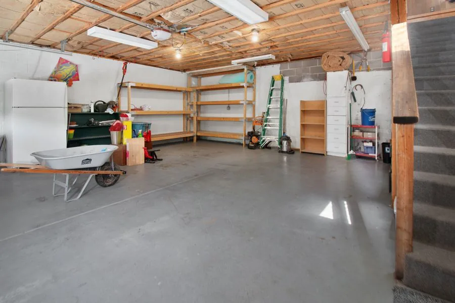 A residential garage interior cleared out with tidy storage shelving