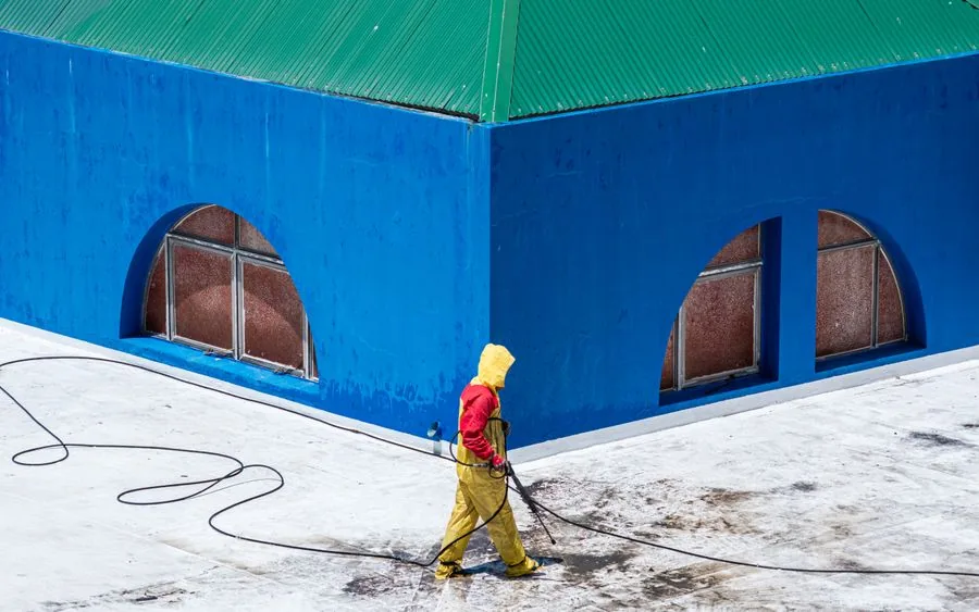 A vetted local pro pressure washing a building exterior