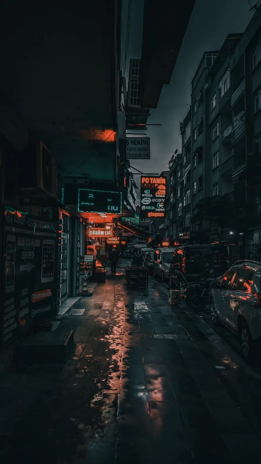 A quiet city street glowing late at night