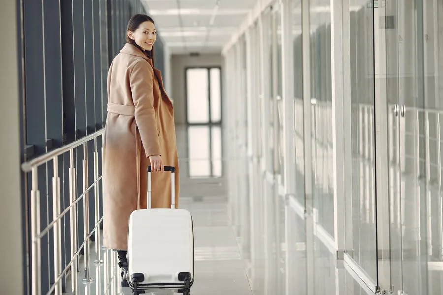 A traveler heading through the airport with a suitcase
