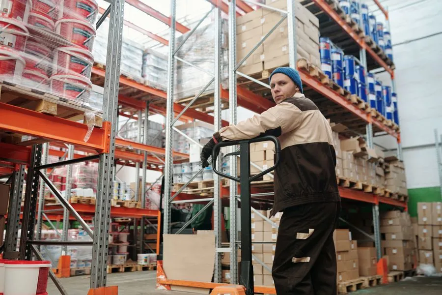 A warehouse worker moving stock among shelves