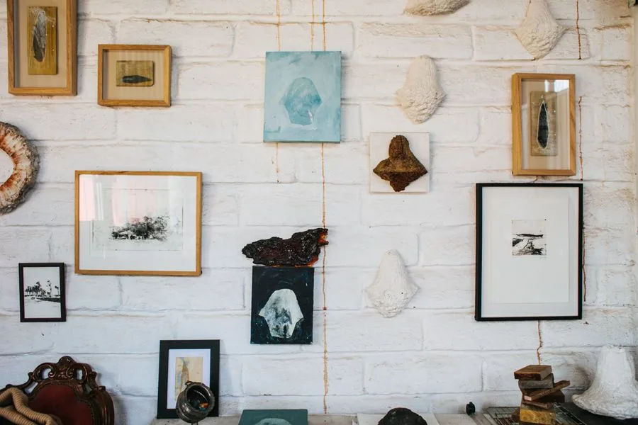 A gallery wall of framed artwork hung in a neat arrangement