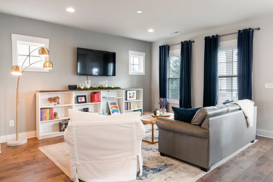 A bright living room with curtains hung neatly over the windows