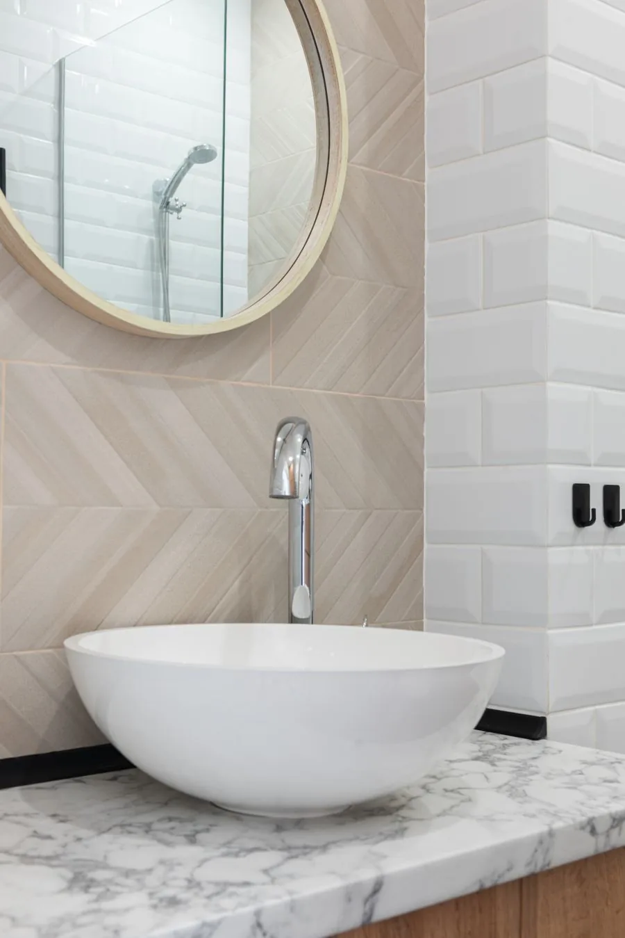 A clean modern faucet on a vessel sink in a bright bathroom