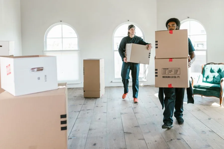 Two vetted local movers carrying boxes inside a home