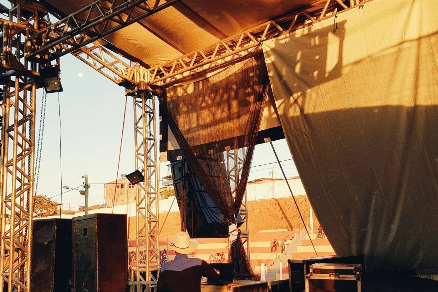 Stage truss and road cases mid load-in at an outdoor venue